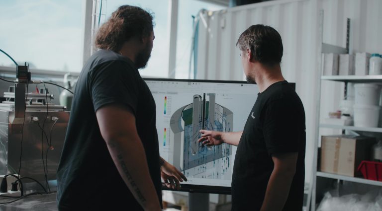 UP Catalysts engineers looking at simulation models on a screen depicting SOLIDWORKS Simulations.